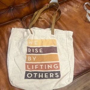 “Rise by lifting others” beach bag in GUC